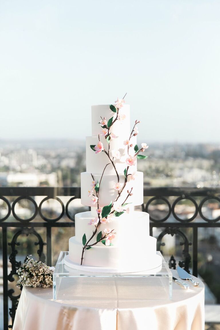 Modern white wedding cake with cherry blossom decorations