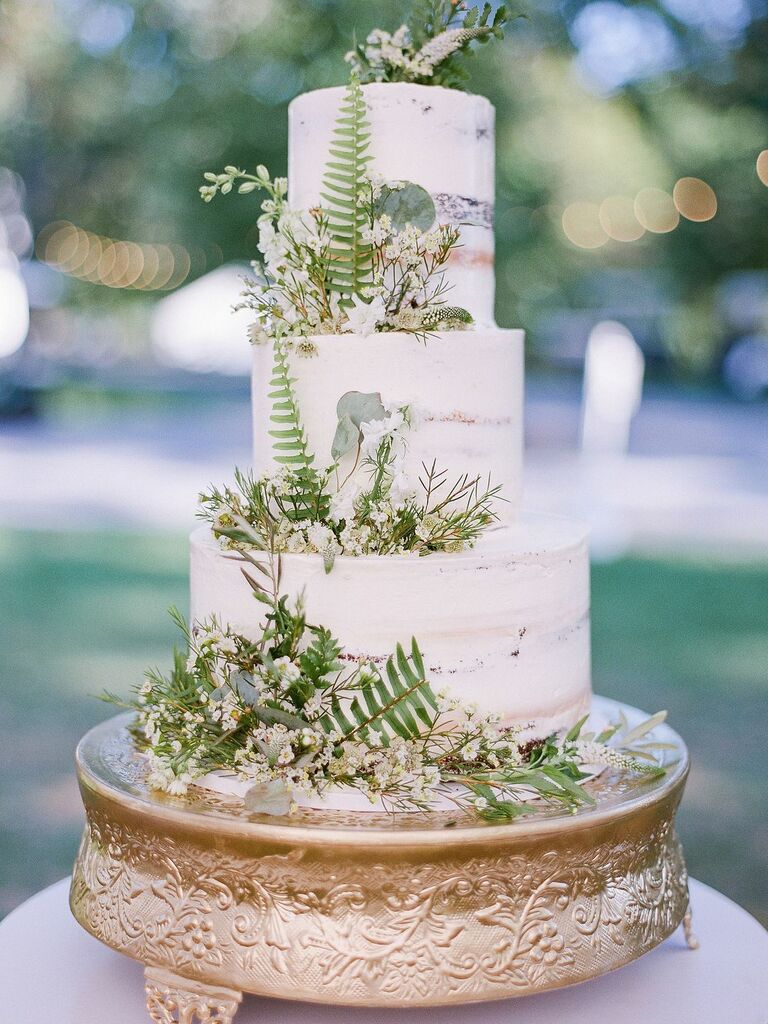 Semi-naked three-tier cake with fern and baby's breath decorations