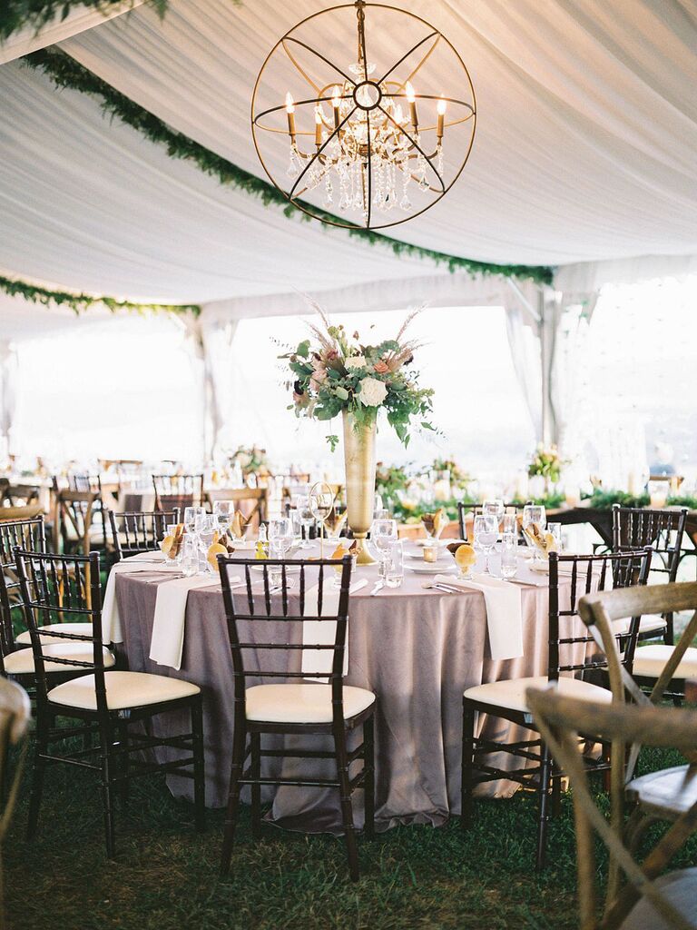Modern chandelier hanging from outdoor wedding tent