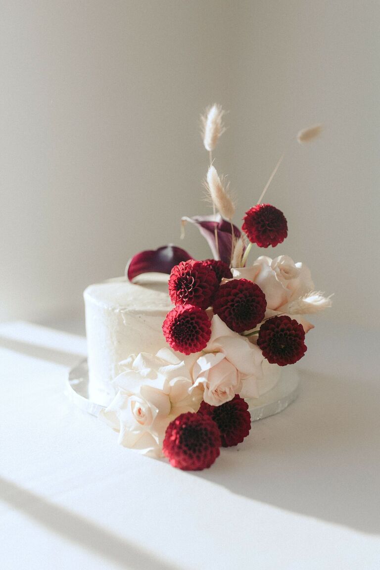 One-tier cake with fresh burgundy dahlia and cally lily blooms.