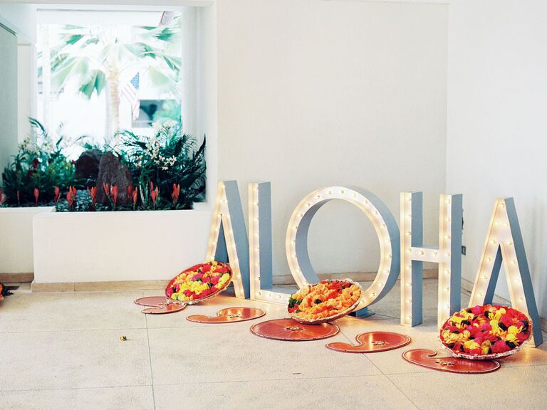 White light-up marquee letters in "Aloha" at wedding reception entrance