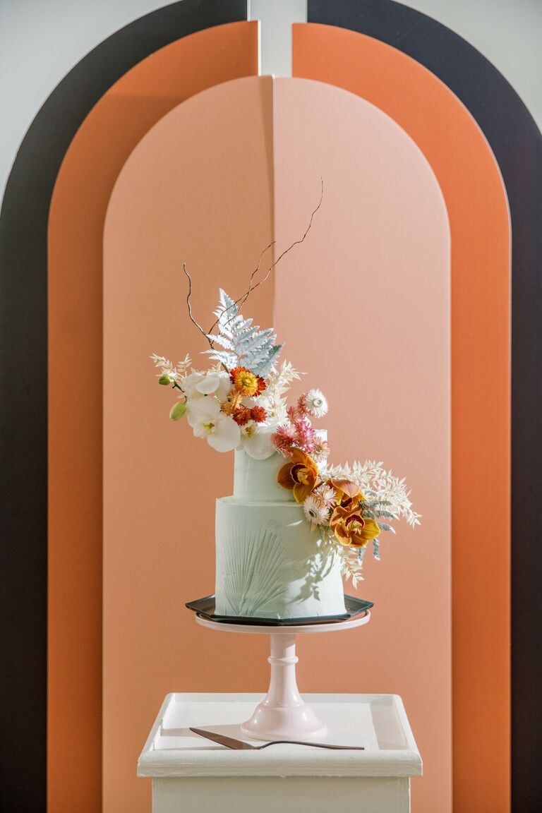 Mint wedding cake with dramatic orange backdrop