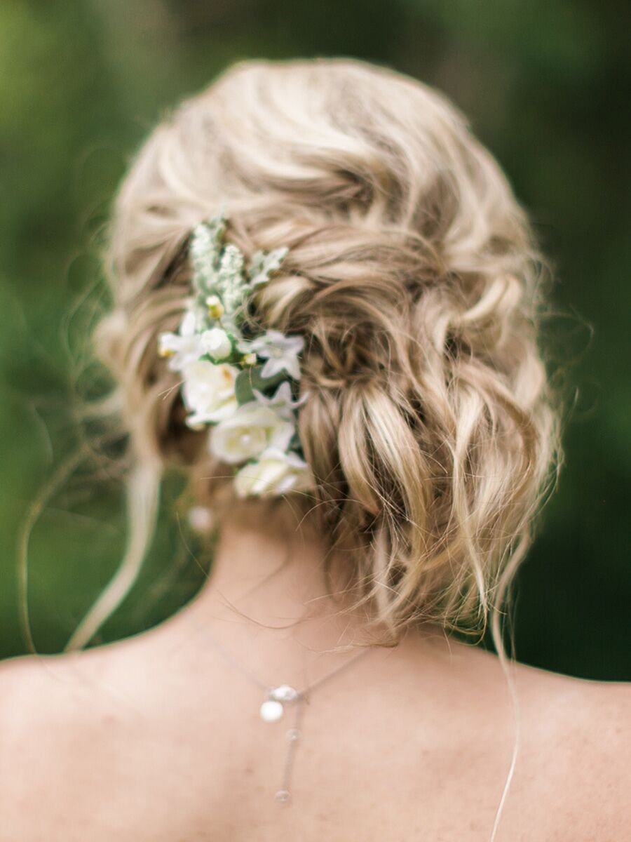 Das Hinzufügen von Blumen zu einem unordentlichen Side-Swept-Brötchen erzeugt einen einfachen und eleganten Chignon