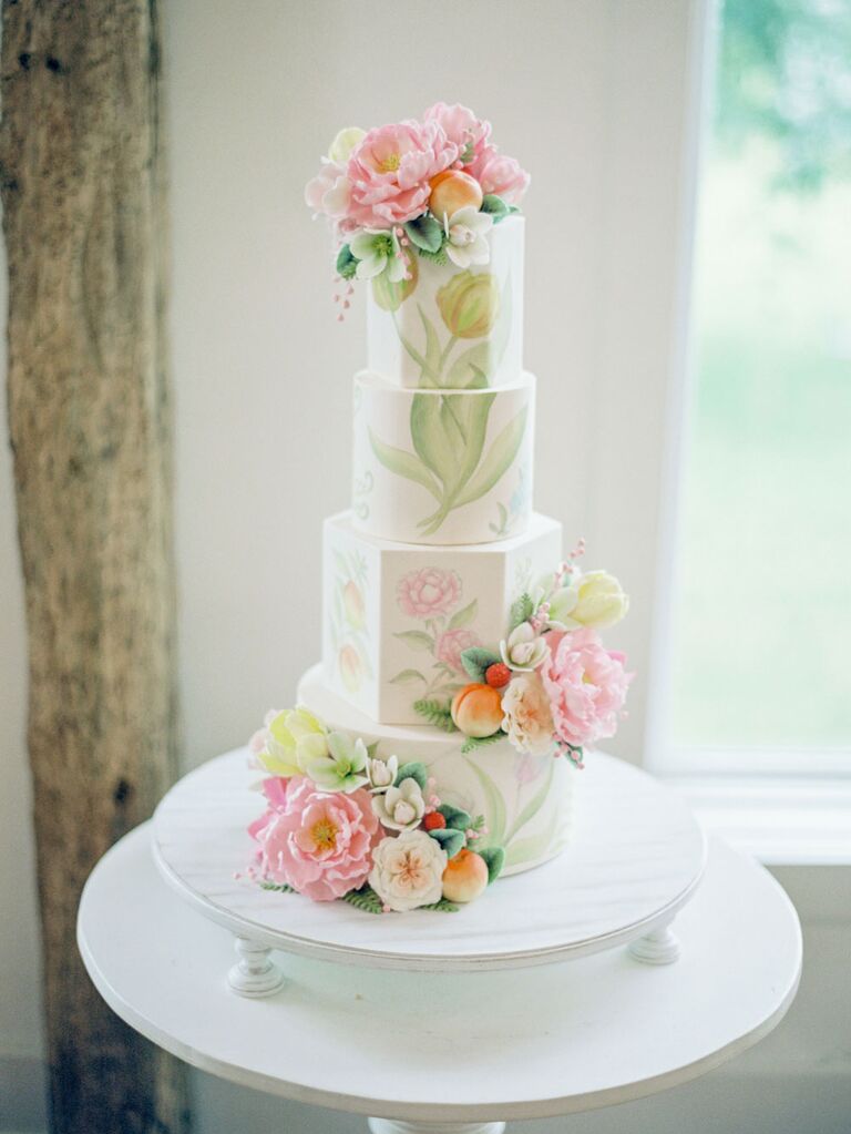 Four-tier white wedding cake with pastel botanical hand-painted art decoration