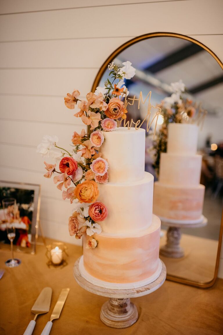 Three-tier orange ombre wedding cake with orange flowers