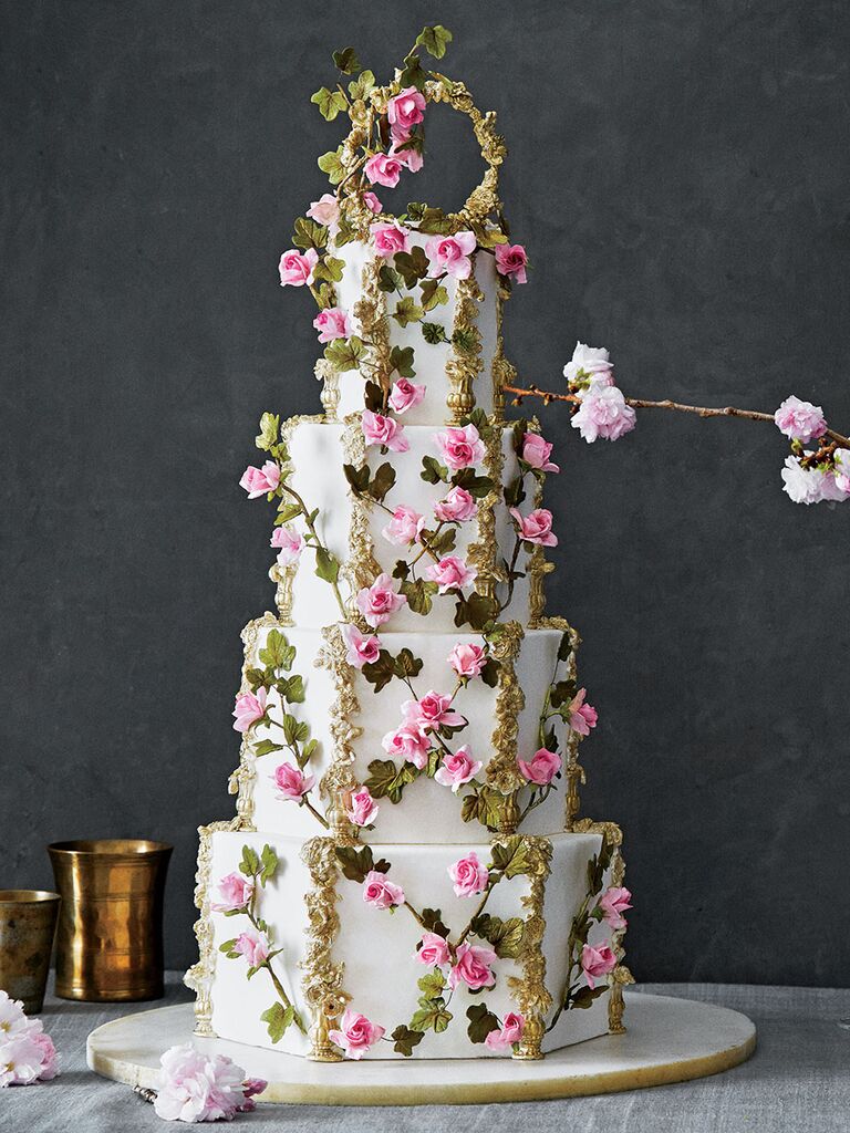 Ornate four-tier wedding cake with pink flowers