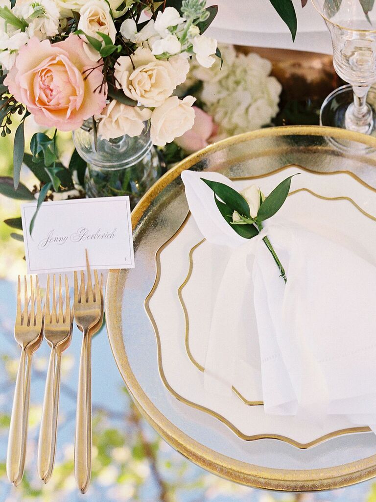 White and gold mismatched china plates on wedding reception tables