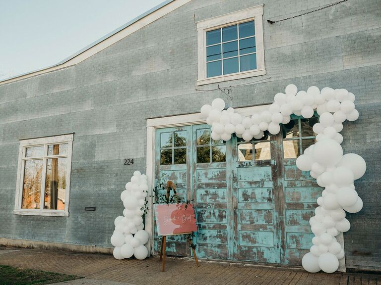 White balloon arch around entrance at industrial wedding reception venue