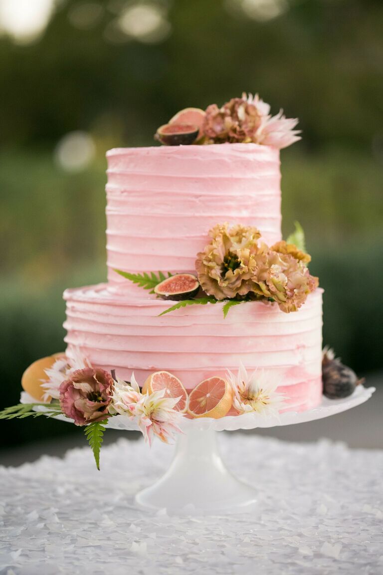 Two-tier pink cake with fresh fruit decorations