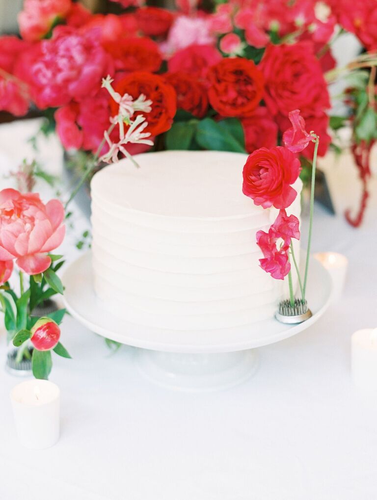 Single-tier white cake with pink fresh flower accents