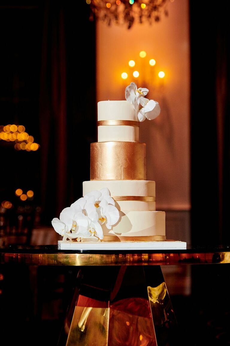 Gold-and-white wedding cake with orchids