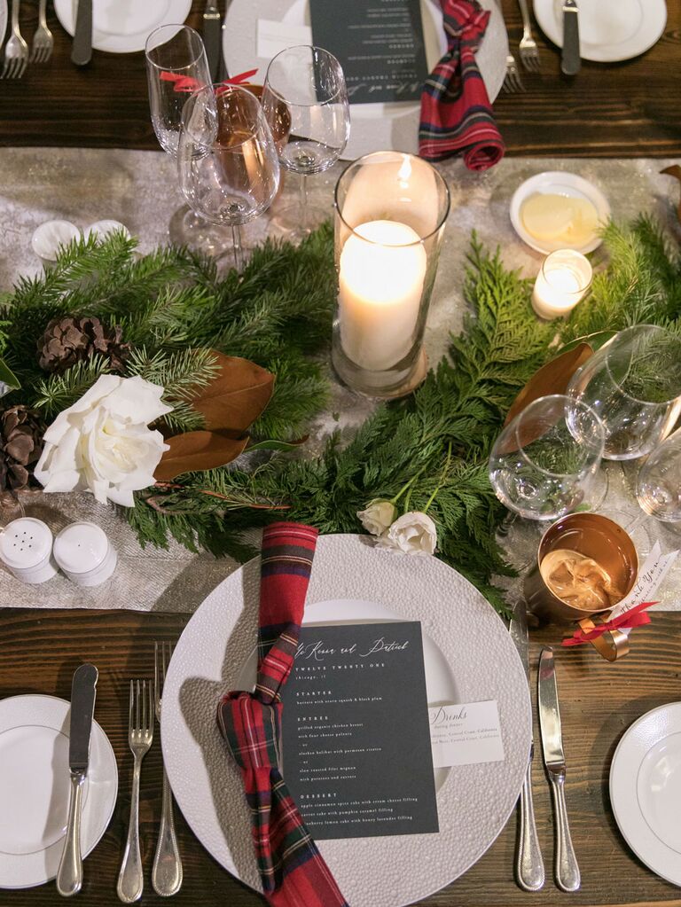 Christmas-inspired tablescape with plaid napkins and pine garland at winter wedding reception