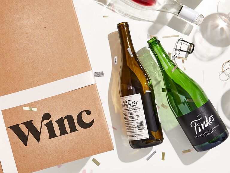 Коричневая упаковка с черными буквами Winc рядом с пустыми бутылками из-под вина