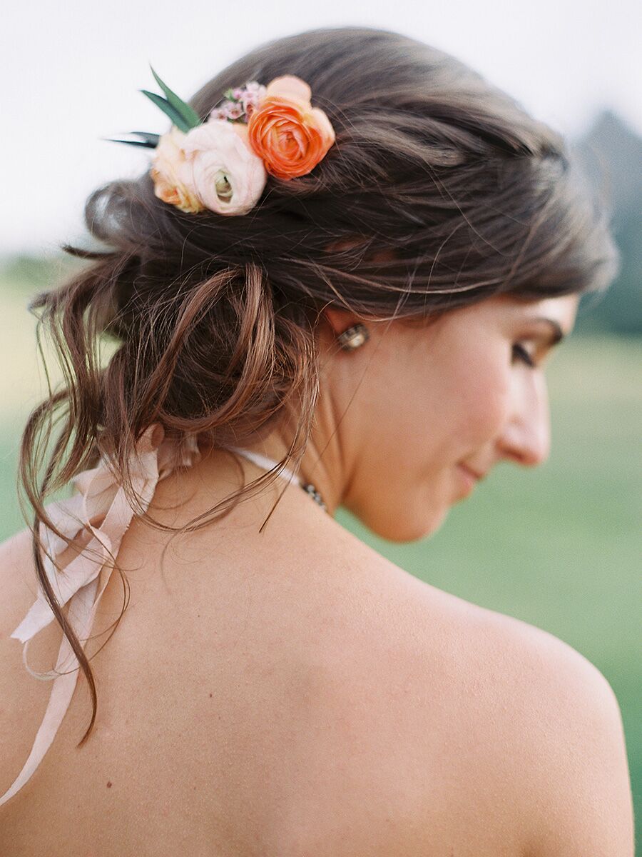 Brudepike updo ide for en stroppeløs kjole med et par friske blomster